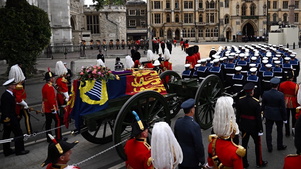 Un moment phare des funérailles: Le cercueil sur un canonnier accompagné par des cornemuses.