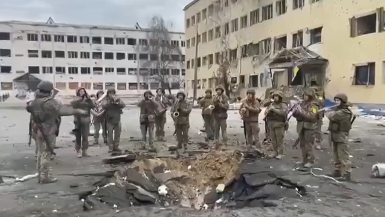 Quelle émotion: L'Hymne national ukrainien joué par des militaires devant le cratère d'une bombe. - cratere