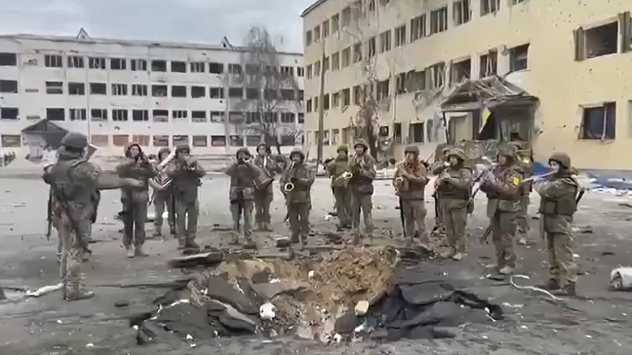 Quelle émotion: L&rsquo;Hymne national ukrainien joué par des militaires devant le cratère d&rsquo;une bombe.