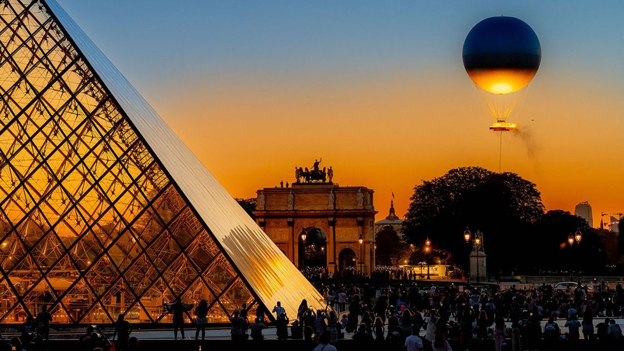 FRANCE. PARIS (75) 1ST ARRONDISSEMENT. PYRAMIDE DU LOUVRE. FOR THE DURATION OF THE PARIS 2024 GAMES, THE OLYMPIC FLAME WILL HANG OVER THE JARDIN DES TUILERIES IN THE HEART OF PARIS.  THE 30 M HIGH VASQUE  (MADE OF WATER AND LIGHT WITHOUT FUEL, 100% ELECTRIC!), RISES INTO THE SKY, LIKE A MONTGOLFIERE. IT HANGS FROM A RING CONTAINING THE OLYMPIC FLAME (CREATED BY DESIGNER MATHIEU LEHANNEUR). PLACED ON THE GROUND DURING THE DAY, IT RISES INTO THE PARISIAN SKY EVERY EVENING. (Photo by Christophe LEPETIT / ONLY FRANCE / Only France via AFP)
